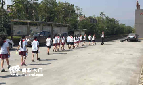 当地小学师生离开重庆朗彩木门厂区  挥手告别