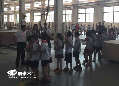 当地小学师生前往重庆朗彩木门厂区进行参观学习  学生仔细听讲